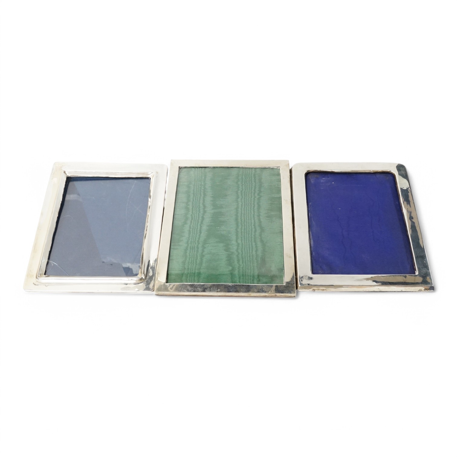 Three assorted early 20th century silver mounted photograph frames, including Birmingham, 1916, (some marks rubbed), largest 27cm. Condition - poor to fair